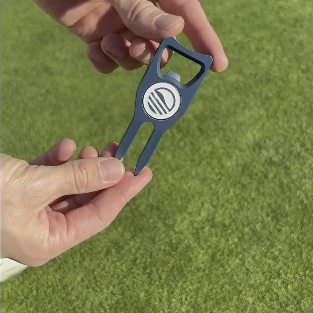 Divot tool demonstrating its functionality, including the attached ball marker