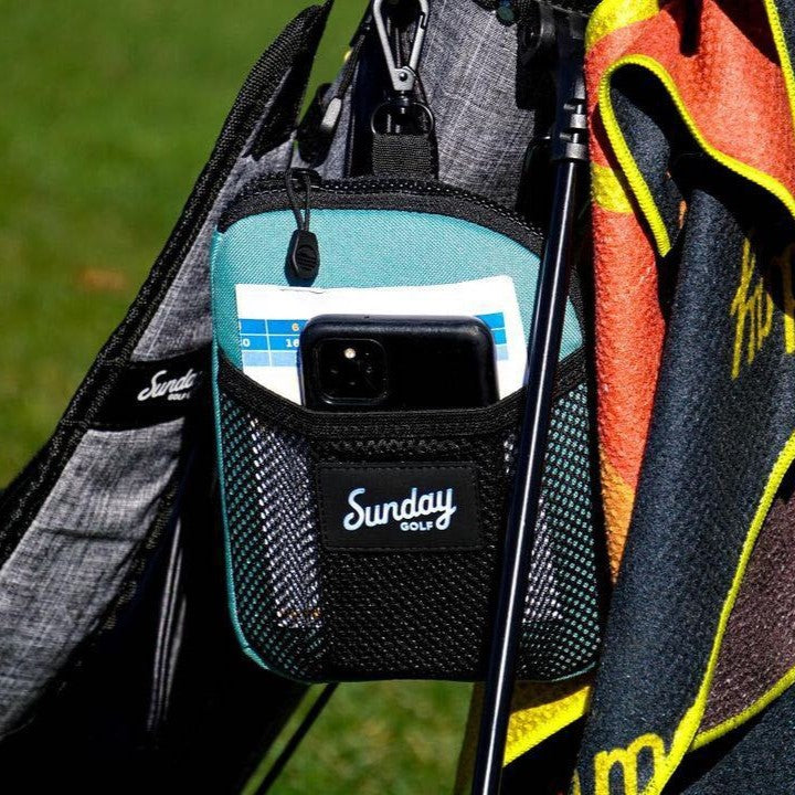 Seafoam green nickel bag clipped on a golf bag with items on it