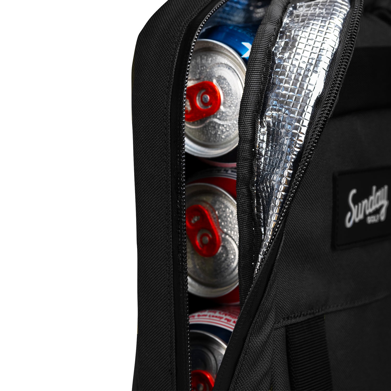 A close up shot of big frosty golf cooler bag in matte black partially unzipped showing canned drinks inside