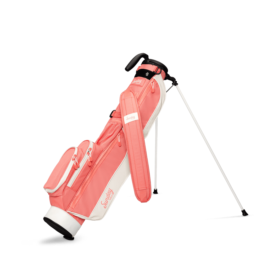 A full front shot of standing Loma golf bag in coral with single strap