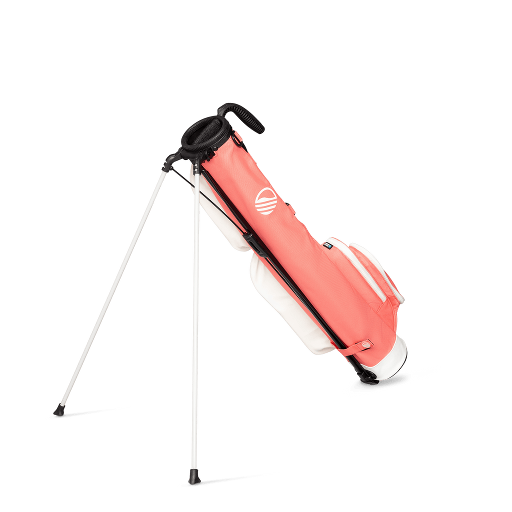 A full shot of standing Loma golf bag in coral facing backward