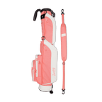 A full shot of Loma golf bag in coral laying flat sideways beside its single strap