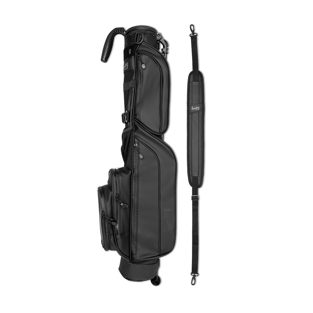 A full shot of Loma S-Class golf bag in black vegan leather laying flat sideways beside its single strap
