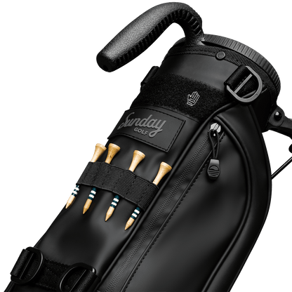 A close up of Loma S-Class golf bag in black vegan leather showing the front with bamboo golf tees