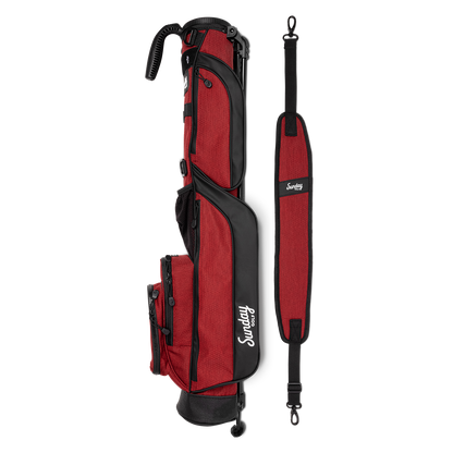 A full shot of Loma golf bag in ron burgundy laying flat sideways beside its single strap