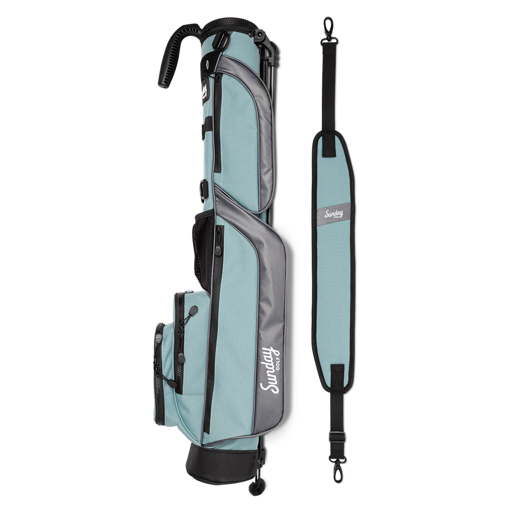 A full shot of Loma golf bag in seafoam laying flat sideways beside its single strap