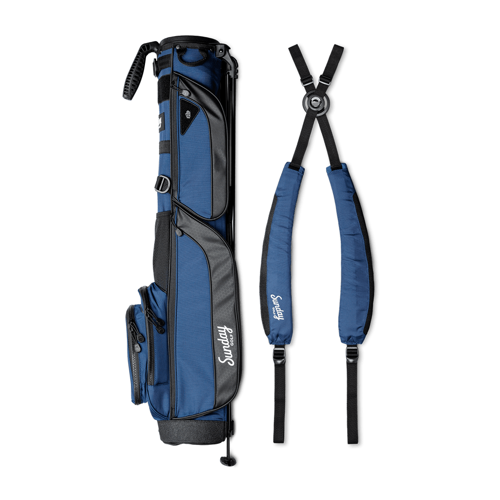 A full shot of Loma XL golf bag in cobalt blue laying flat sideways beside its double strap