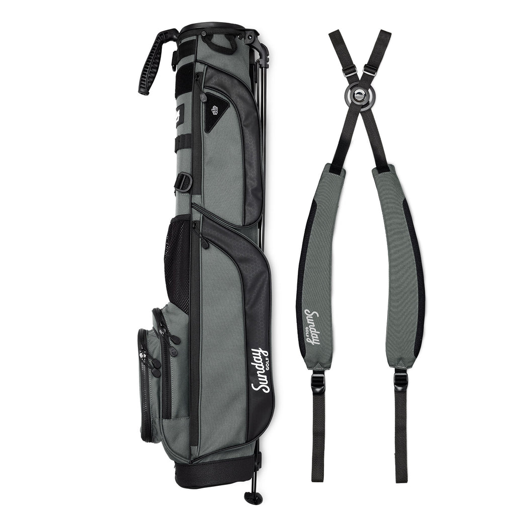 A full shot of Loma XL golf bag in midnight green laying flat sideways beside its double strap