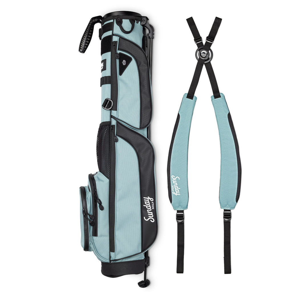 A full shot of Loma XL golf bag in seafoam green laying flat sideways beside its double strap