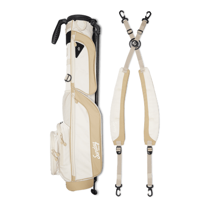 A full shot of Loma XL golf bag in toasted almond laying flat sideways beside its double strap