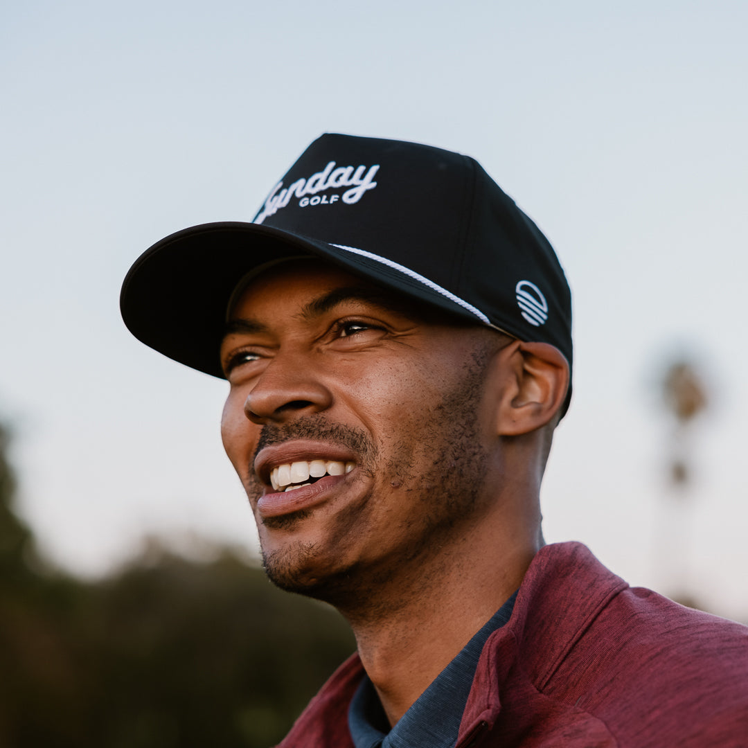A man wearing black and white rope hat by sunday golf