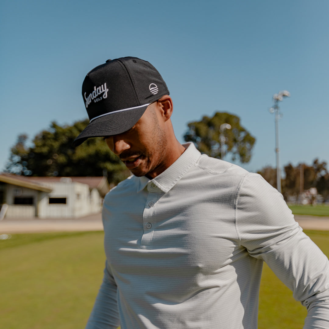 man wearing black and white rope hat by Sunday Golf