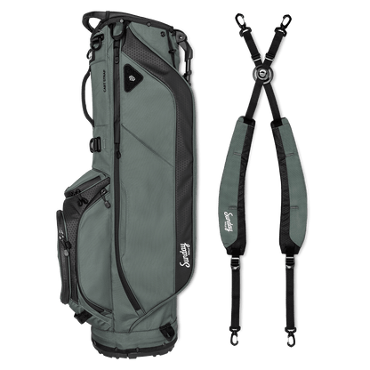 A full shot of Ryder golf bag in midnight green laying flat sideways beside its double strap