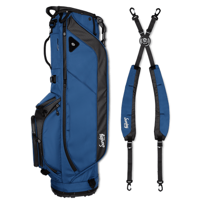A full shot of Ryder golf bag in navy blue laying flat sideways beside its double strap