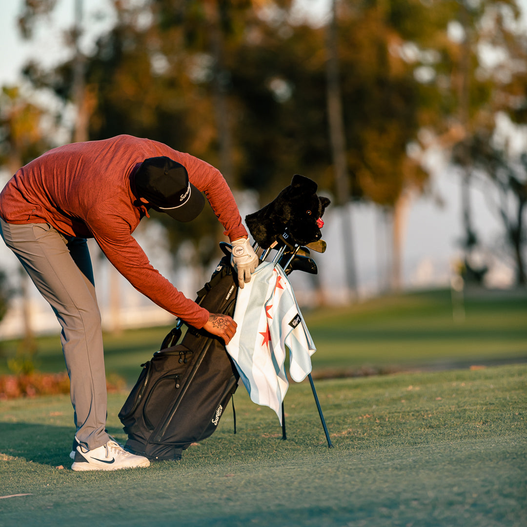 man on golf course with chicago golf towel attached to his golf bag