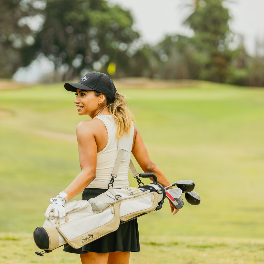 Woman carrying toasted almond Loma golf bag on course