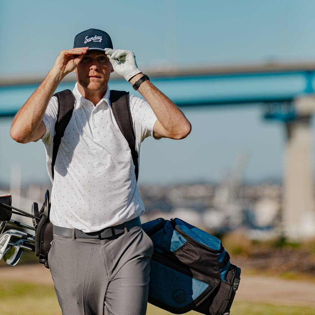 A man wearing navy rope golf hat by Sunday Golf with Coronado Bridge in background 