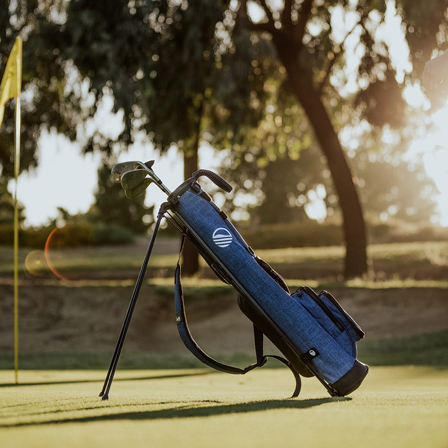 A full front shot of standing Loma golf bag in cobalt blue with single strap on the course