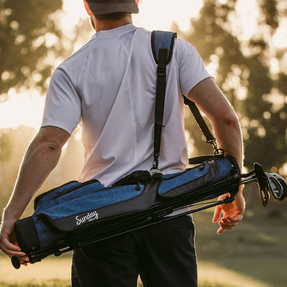 A man carrying a cobalt blue Loma golf bag using its single strap