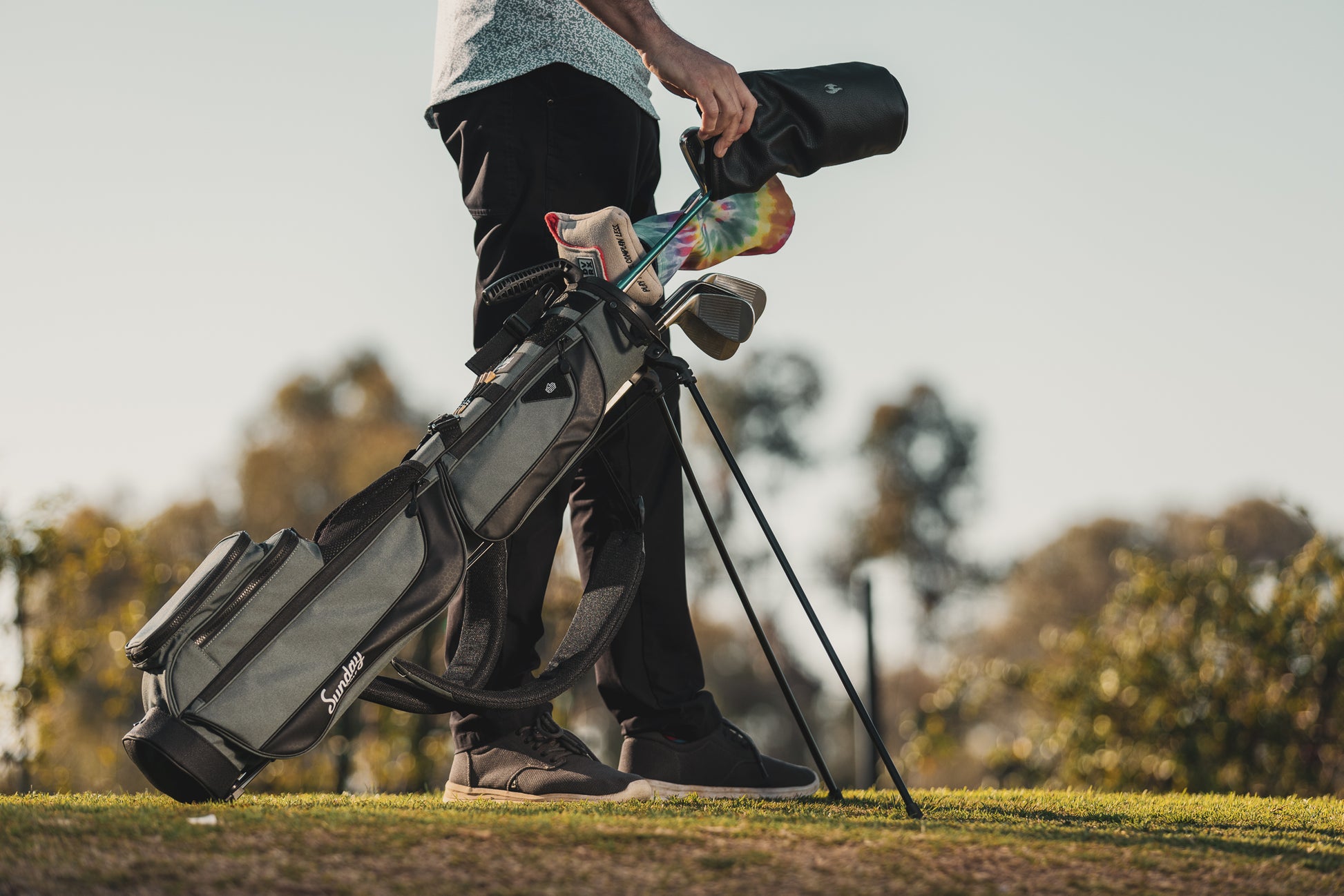 A full front shot on the course of standing Loma XL golf bag in midnight green with double strap
