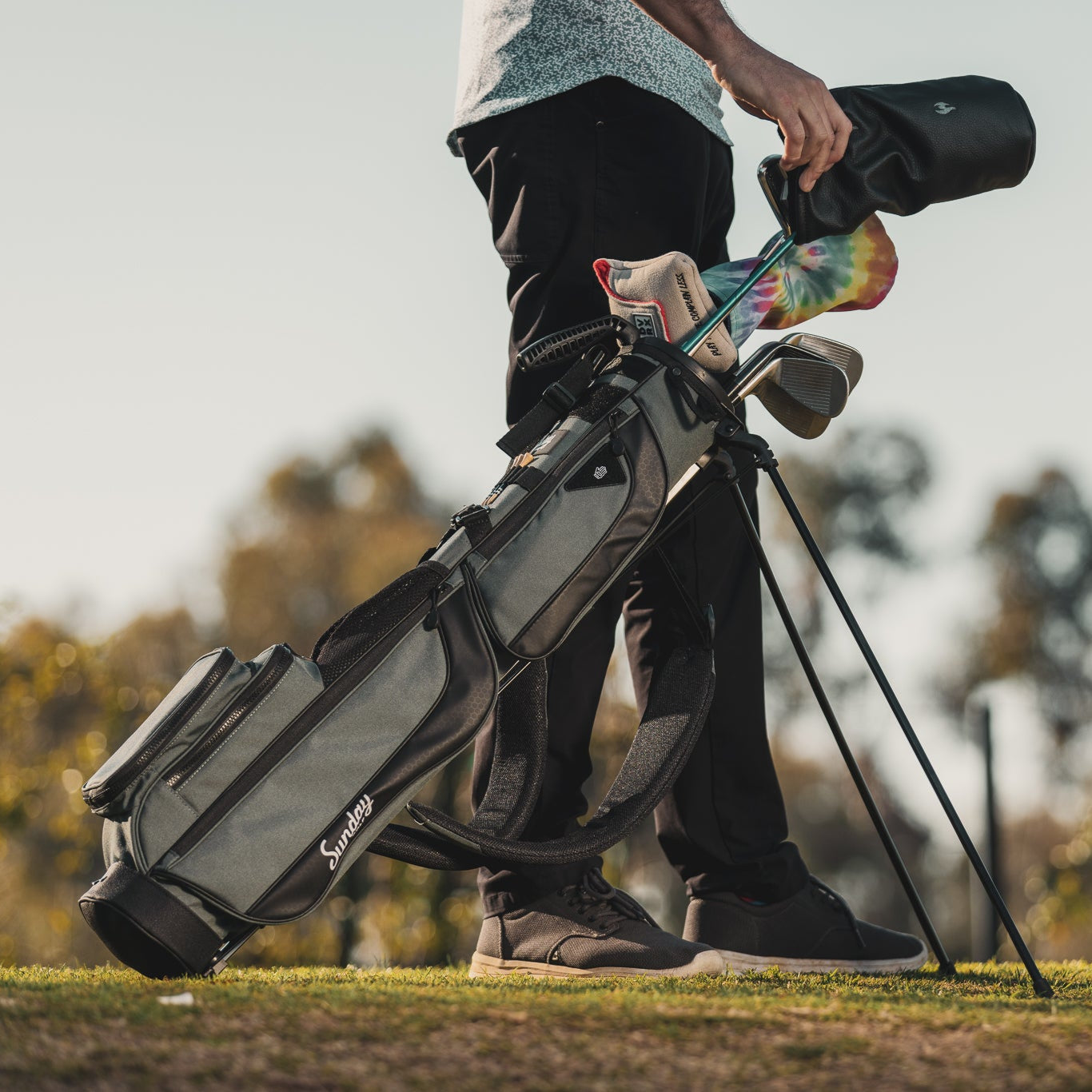 A full front shot on the course of standing Loma XL golf bag in midnight green with double strap