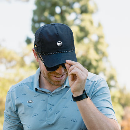 A man tipping down his black Porter Lite golf hat
