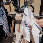 El Classico white red and blue golf towel on a Sunday golf bag being used to wipe a golf club